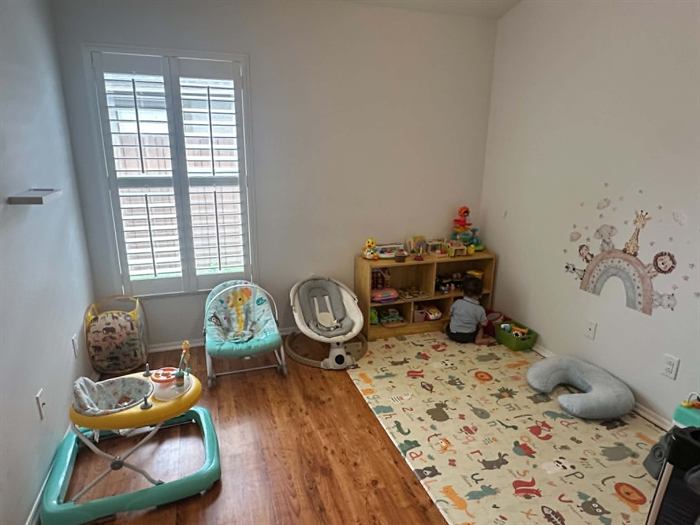 Bright, sunlit play area with soft toys and a cozy activity table at Amany's Home Daycare